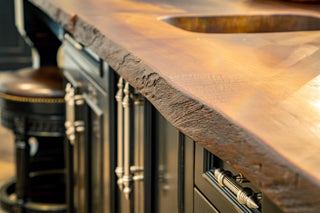 Custom wood-look concrete countertops with rustic edges in a kitchen.